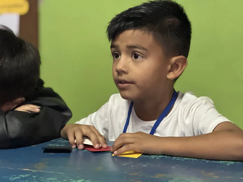 A boy participates in an international Crossroads club lesson.