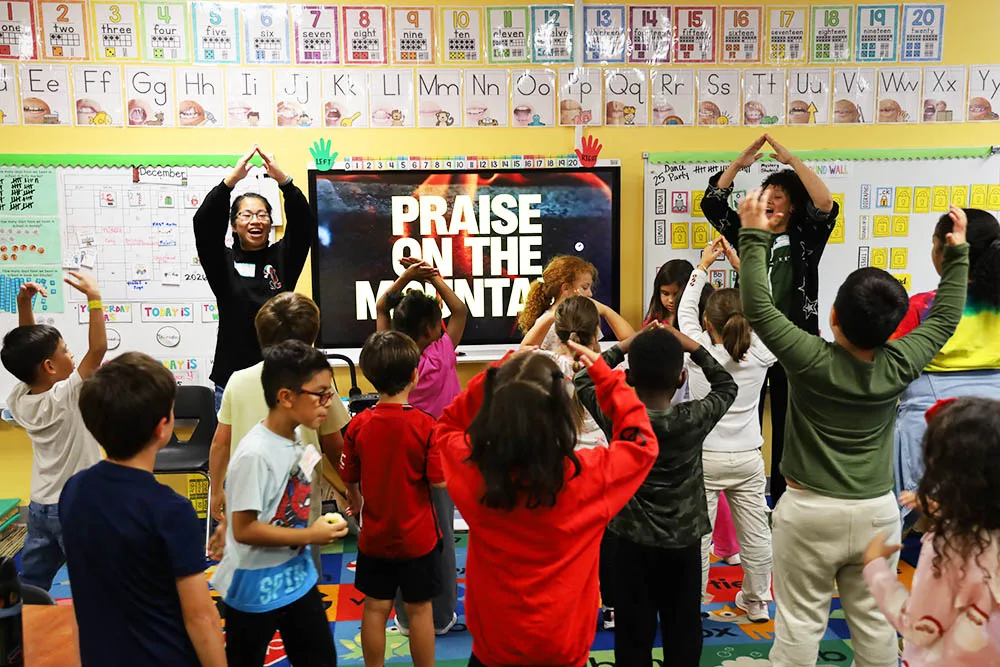 A leader sharing the gospel with children