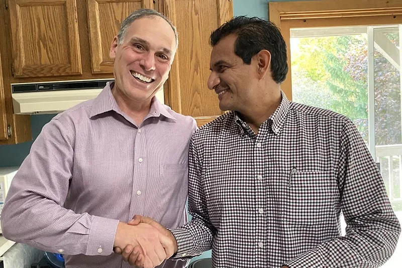 Two ministry leaders shake hands over a signed agreement.