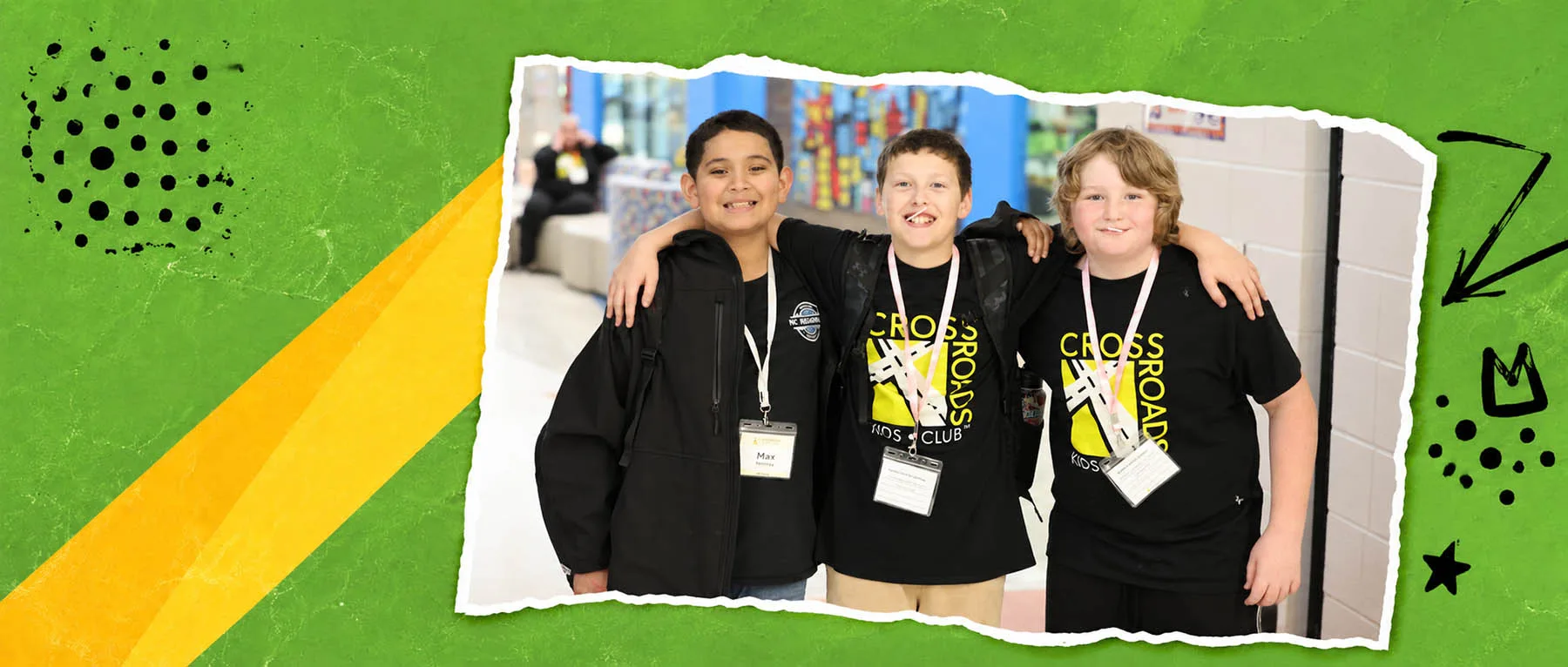 Three boys smile with their arms around one another at Crossroads Kids Club.